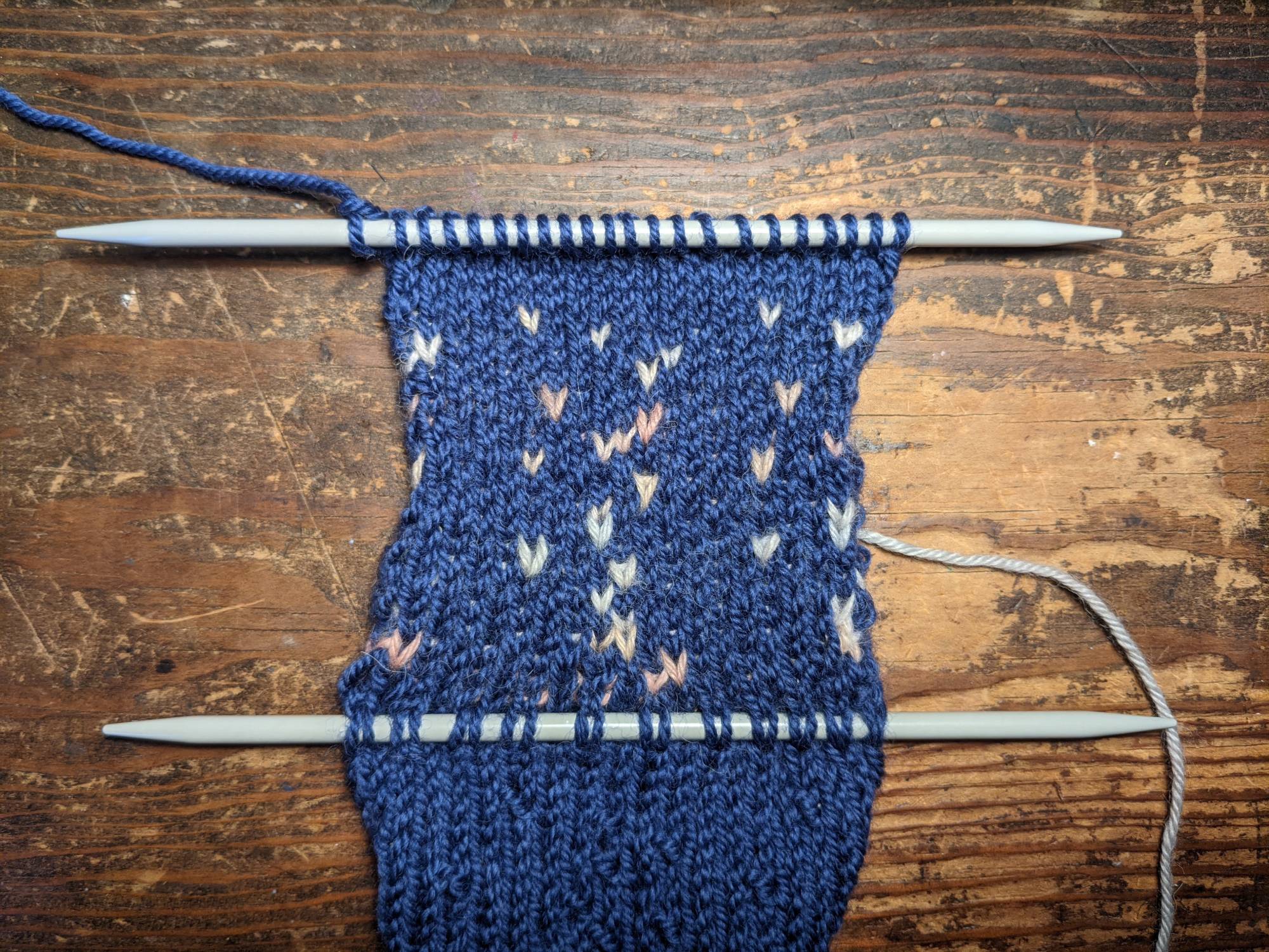 Close-up view of a knitted piece showcasing letters and a two-color pattern